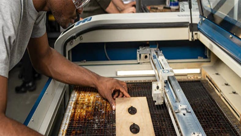 Man working on laser cutting machine.